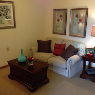 A cozy living room with a sofa, coffee table, and decorative artwork.