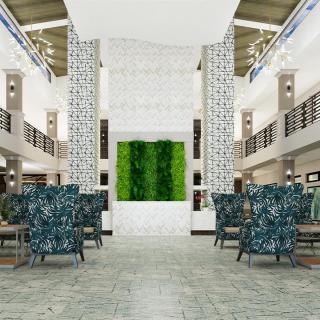 A modern lobby with a green wall and stylish seating arrangements.