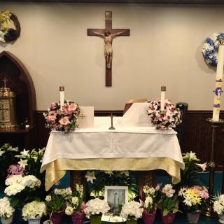 A decorated church altar with a crucifix, flowers, and candles.