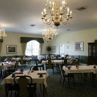 An elegant dining room with chandeliers and neatly arranged tables and chairs.