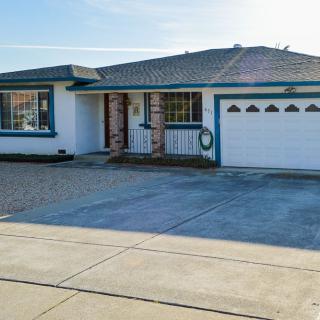 A single-story house with a blue trim, featuring a two-car garage and a spacious driveway.