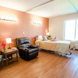 A well-lit hospital room with a bed and recliner chair, designed for patient comfort.