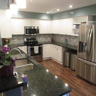 Modern kitchen with stainless steel appliances and granite countertops.