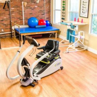 A well-equipped physical therapy room featuring an exercise bike and various rehabilitation tools.