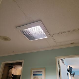 A modern ceiling light illuminating a room with soft colors.