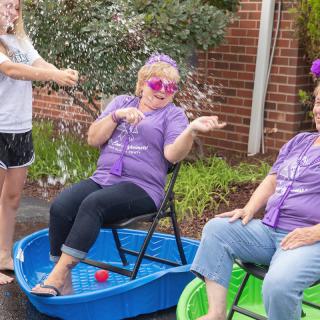 A group of people enjoying a playful outdoor gathering with kiddie pools.