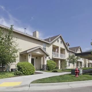 A residential building with well-maintained landscaping and a clear blue sky.