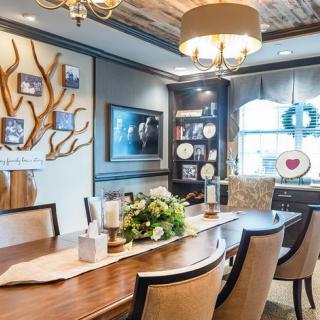 A beautifully decorated dining room with a large wooden table, elegant chairs, and stylish artwork on the walls.