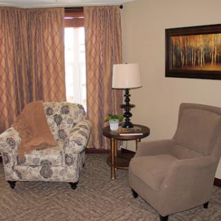 A cozy living room setup featuring comfortable seating, decorative curtains, and a warm ambiance.