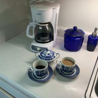 A cozy coffee setup with a machine and two cups on a kitchen counter.