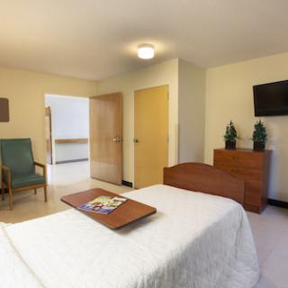 A cozy and well-furnished bedroom with a comfortable bed, seating area, and modern amenities.