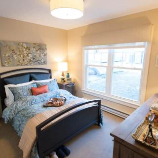 A cozy bedroom with a neatly made bed, warm lighting, and tasteful decor.
