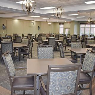 An empty dining hall with neatly arranged tables and chairs.