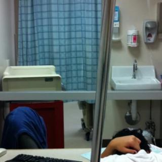 A patient resting on a hospital bed with medical equipment nearby.