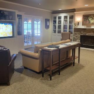 A cozy living room with comfortable seating and a warm atmosphere, featuring a television and a fireplace.