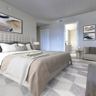 A modern bedroom decorated in neutral tones with a plush bed and contemporary furniture.