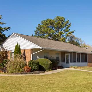 A suburban single-story brick house with a well-maintained yard.