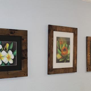A beautiful display of floral-themed paintings in rustic frames.