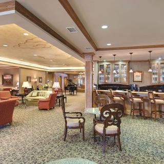 A cozy lounge with seating and a bar area, featuring comfortable furniture and warm lighting.