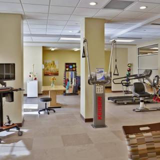 A spacious gym interior with various exercise equipment and workout areas.