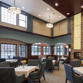 A modern dining area with elegant tables and seating, featuring large windows and stylish lighting.