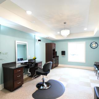 A modern salon interior with stylish furniture and ample lighting.