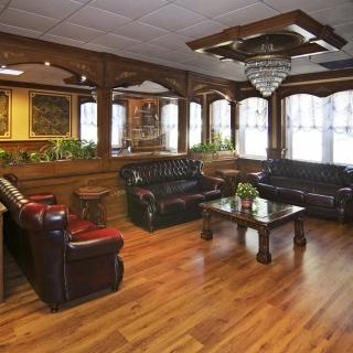 Elegant lobby with leather sofas and a central chandelier.