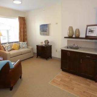 A cozy living room with a sofa, armchair, side table, and decor items.