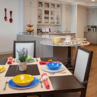 A modern dining area with a colorful table setting and an open kitchen in the background.