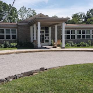 A modern school building with a welcoming entrance surrounded by greenery.