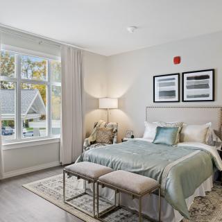 A modern bedroom with large windows and elegant decor.