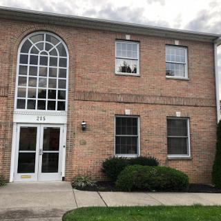 A brick building featuring elegant windows and a welcoming entrance.