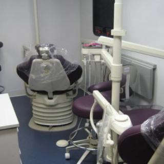 A dental office with a dentist chair and medical equipment.