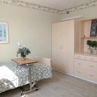 A simple, well-lit room with a hospital bed and minimalist decor.