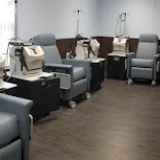 A clean and organized medical treatment area featuring comfortable chairs for patients undergoing procedures.