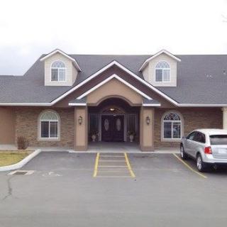 A front view of a residential-style building with a parked car.