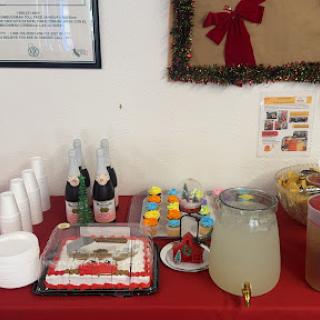 A festive table set up for a celebration featuring cake, snacks, drinks, and festive decor.