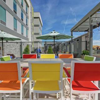 A vibrant outdoor seating area with colorful chairs and umbrellas, perfect for enjoying the sunshine.