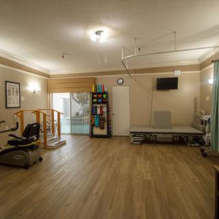 A spacious rehabilitation room with various exercise equipment for physical therapy.