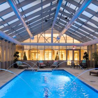 A luxurious indoor pool with a glass ceiling and elegant lighting, perfect for relaxation.
