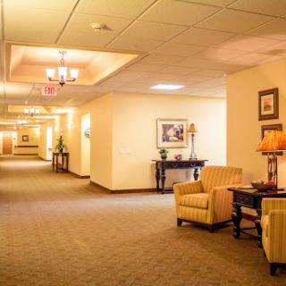 A well-lit hallway featuring comfortable seating and decorative elements, creating a welcoming atmosphere.