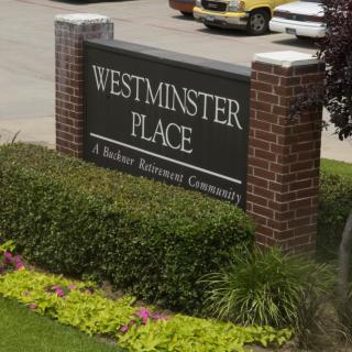 Entrance sign for Westminster Place, a senior retirement community, surrounded by well-maintained landscaping.