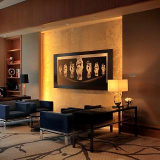 A modern lobby featuring a seating area with contemporary furniture, ambient lighting, and artistic wall decor.