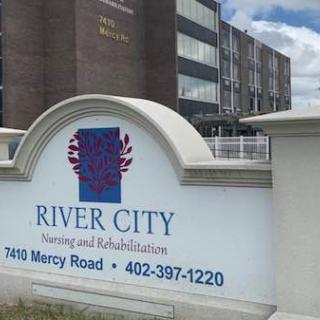 Sign for River City Nursing and Rehabilitation located in front of a healthcare building.