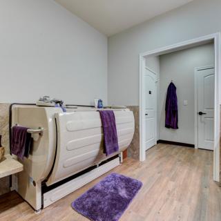 A modern bathroom featuring a unique bathtub and purple accents.