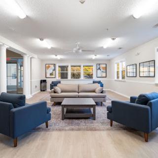 A cozy lounge area featuring modern furniture and ample natural light.