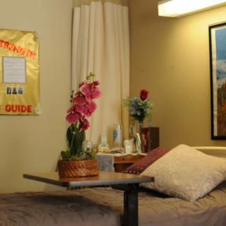 A cozy hospital room with a bed, table, and floral decorations.