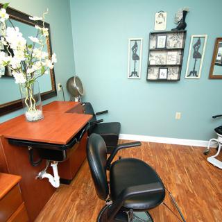 A cozy salon interior with styling chairs, a mirror, and decorative elements.