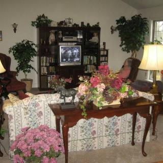 A cozy living room with floral decorations and a classic wooden interior.
