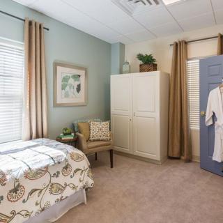 A cozy bedroom with a neatly made bed and stylish decor.